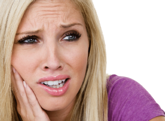 Woman with long blonde hair wearing a purple shirt holds her hand to her cheek and appears to be in pain or discomfort, possibly with a toothache.