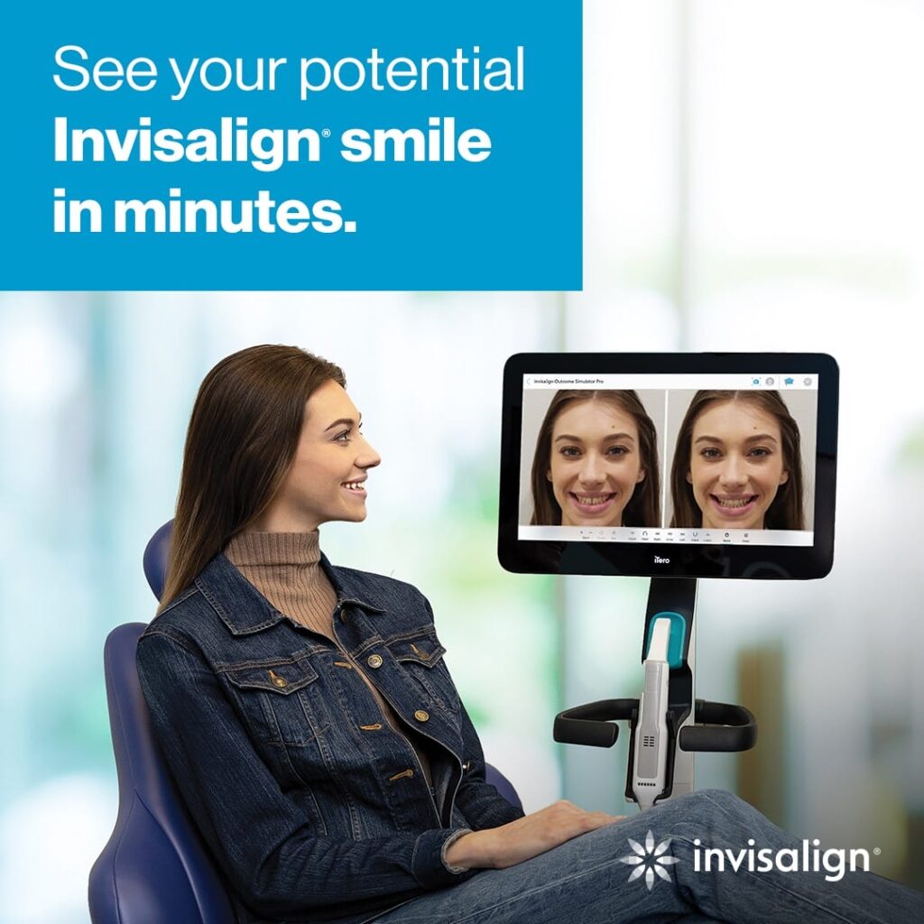 A woman sits in a dental chair, looking at a screen displaying before-and-after images of her smile for an Invisalign treatment.