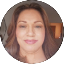 A woman with long brown hair and light makeup smiles softly at the camera in a circular-framed photo, reminiscent of those seen in the smile doctor reviews.